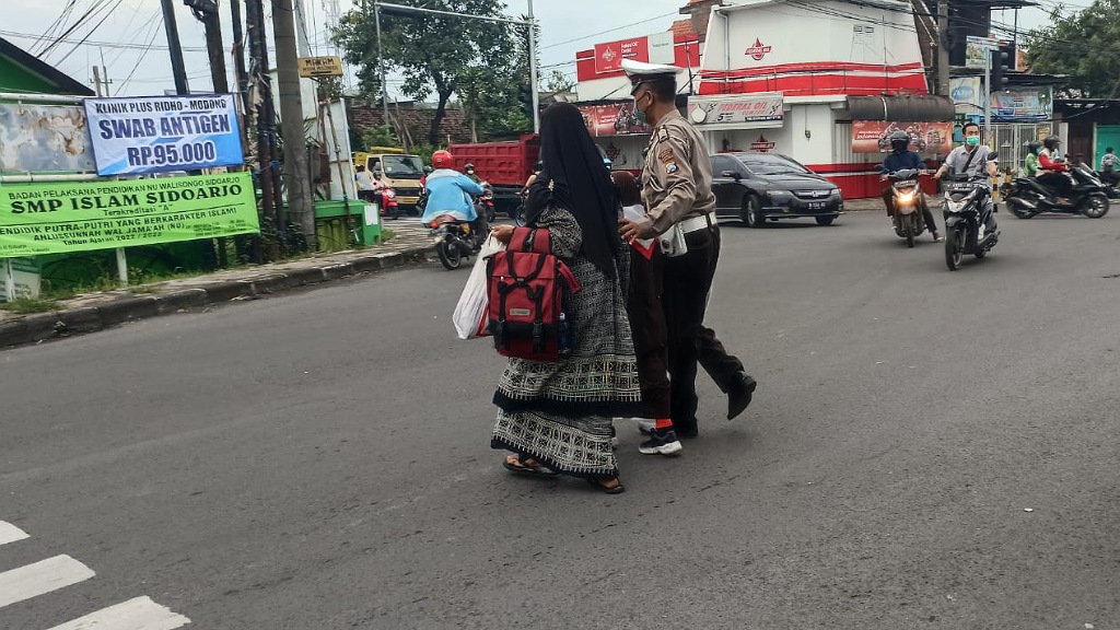 Bantu Warga Seberangkan Jalan, Wujud Pelayanan dan Kepedulian Petugas Polisi